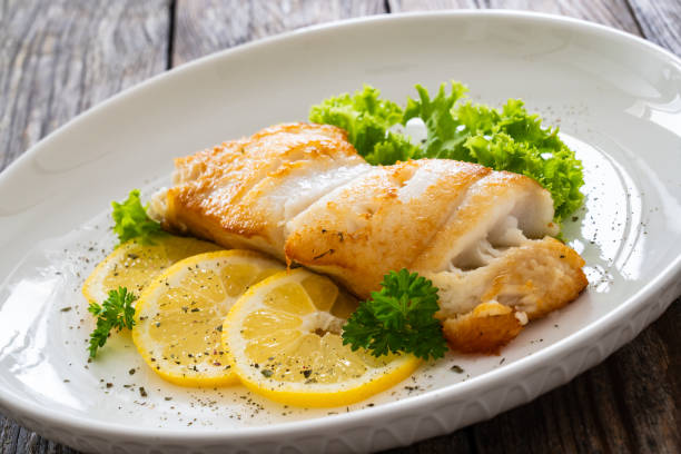 istock Fried halibut steak and fresh vegetables on wooden table 2154052494