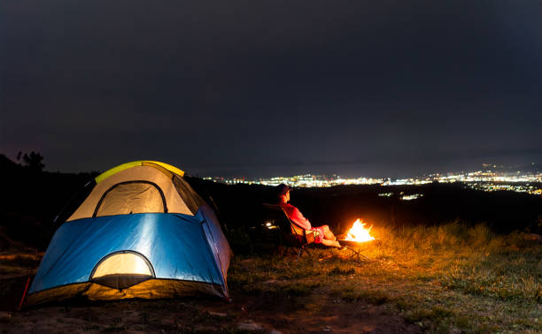 istock One man solo camping looking over city at night 2154052534