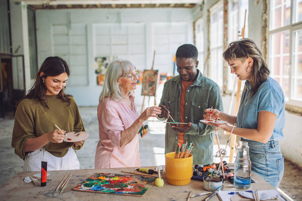 istock Art class engagement: teacher guiding students in painting workshop 2154052912