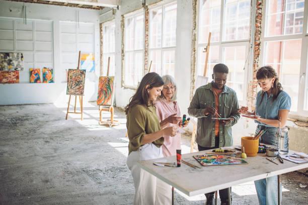 istock Creative workshop: art school teacher guiding students in painting class 2154052973