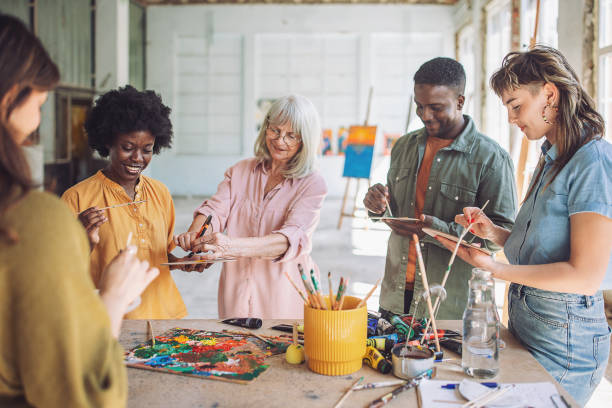 istock Art class in action: teacher guiding students in painting techniques 2154053144