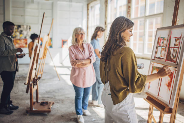 istock Art school creativity: teacher and students engaged in painting class 2154053914