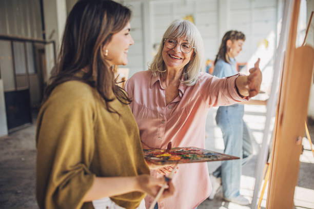 istock Art class creativity: teacher assisting student in painting workshop 2154053943
