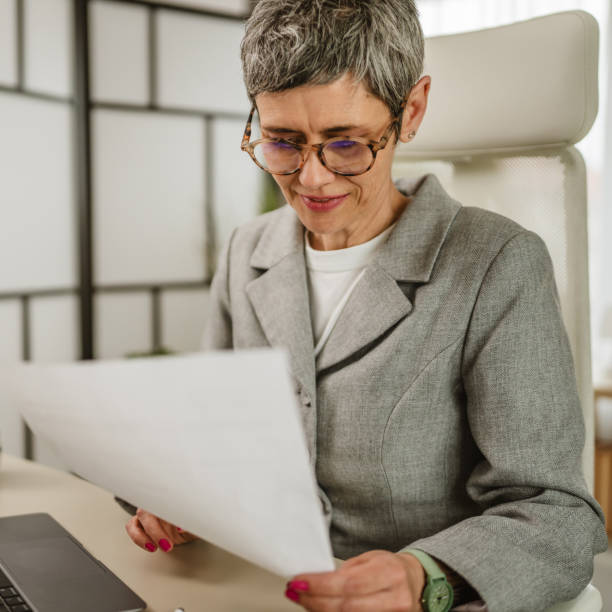 istock One mature caucasian businesswoman work and read document at office 2154054098