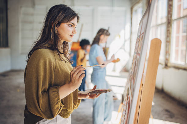 istock Art class creativity: teacher and students engaged in canvas painting 2154054325