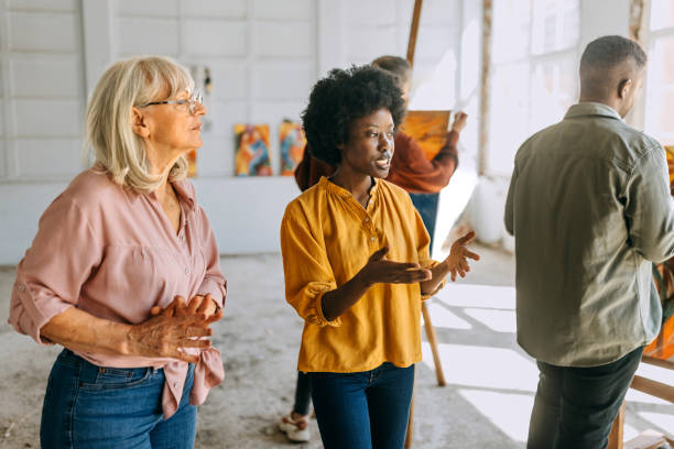 istock Art class in session: teacher guiding students in painting workshop 2154054392