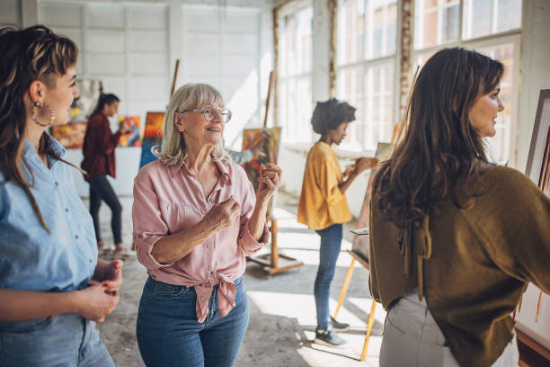 istock Art class inspiration: teacher guiding aspiring painters 2154054533