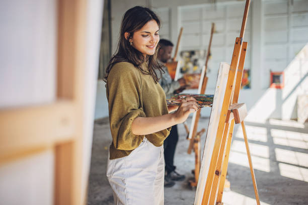 istock Art school creativity: teacher guiding students in painting class 2154054573