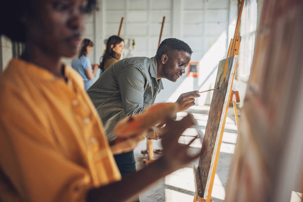 istock Art class in focus: teacher guiding students in painting 2154054664