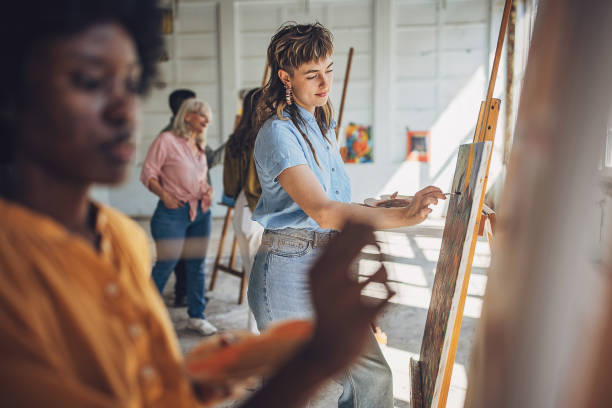 istock Art class in session: teacher guiding students through canvas painting 2154054745