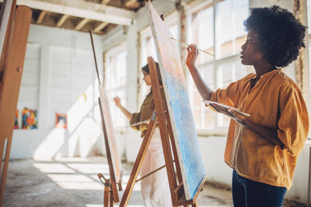 istock Art class in session: teacher guiding students in canvas painting 2154055078