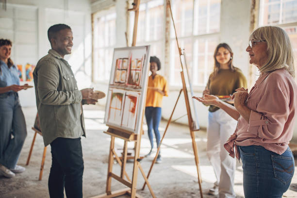 istock Art teacher guiding students in painting workshop 2154055328