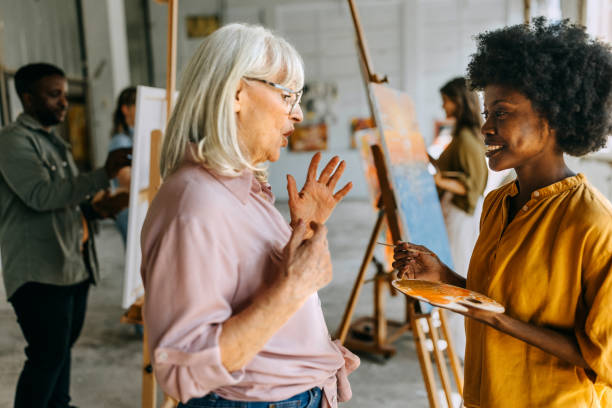 istock Artistic interaction: teacher guiding student in painting workshop 2154055933