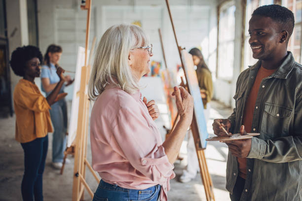 istock Art class enjoyment: teacher and students engaging in canvas painting 2154055999