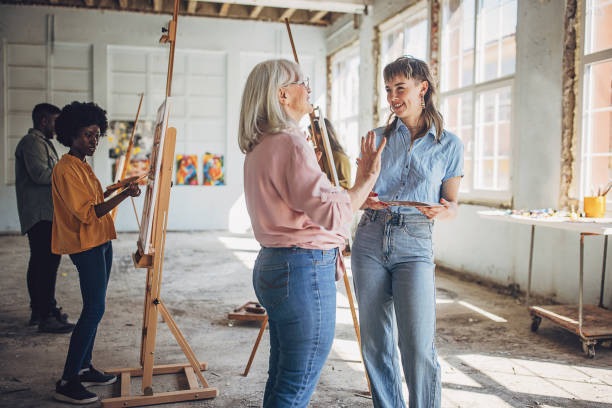 istock Art class inspiration: teacher and students engaged in painting 2154056041