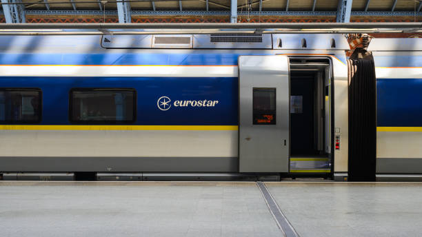 London, UK - March 23, 2024; Eurostar international passenger train waiting at platform with door open and no people in view.  Carriage of train is from side with name of company opertaing service on body of train and open space of platform at bottom
