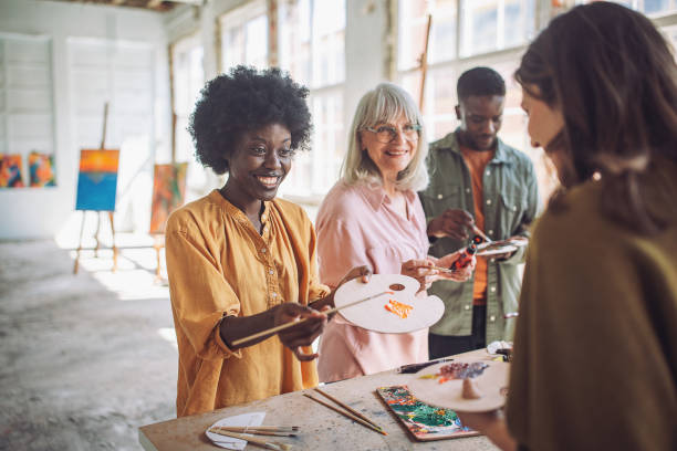 istock Art class enthusiasm: teacher and students engaged in painting 2154056516