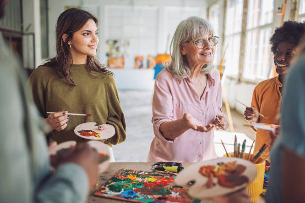 istock Art class in session: teacher and students engaged in painting 2154056655