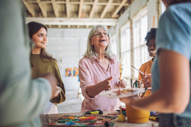 istock Creative learning: art teacher and students in a painting class 2154056677
