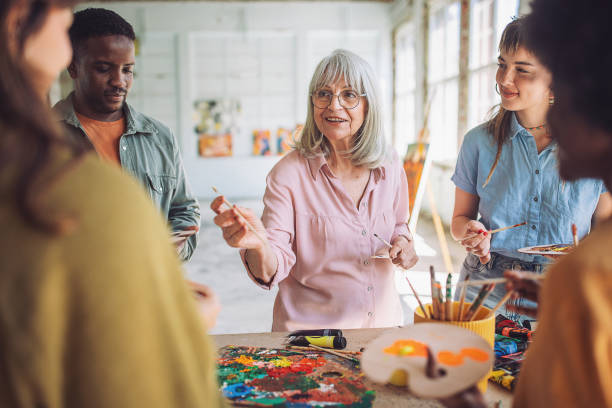 istock Art class in action: teacher guiding diverse students in painting 2154056761