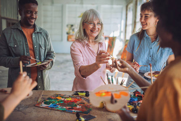 istock Art class creativity: teacher guiding students in painting workshop 2154056772