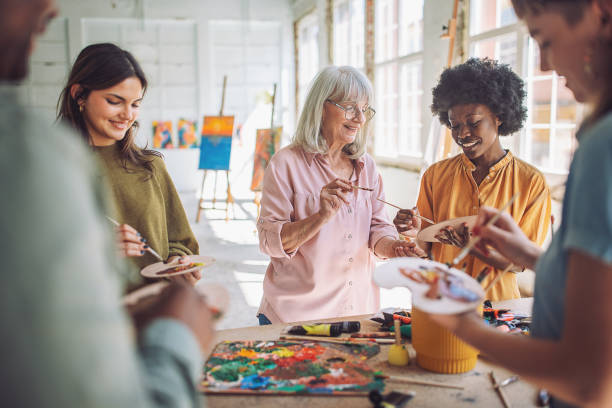 istock Art class in session: teacher guiding students in canvas painting 2154056790