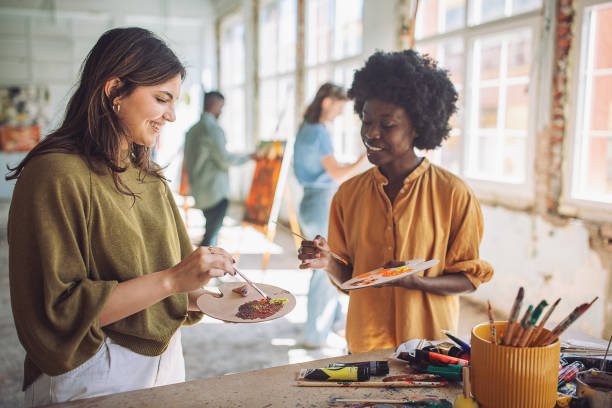istock Art school creativity - teacher guiding students in painting class 2154056810