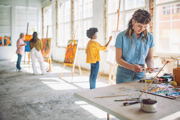 istock Creative process: art teacher and students engaged in painting workshop 2154056959