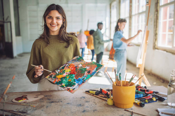 istock Art class in progress: teacher and students engaged in painting 2154057413
