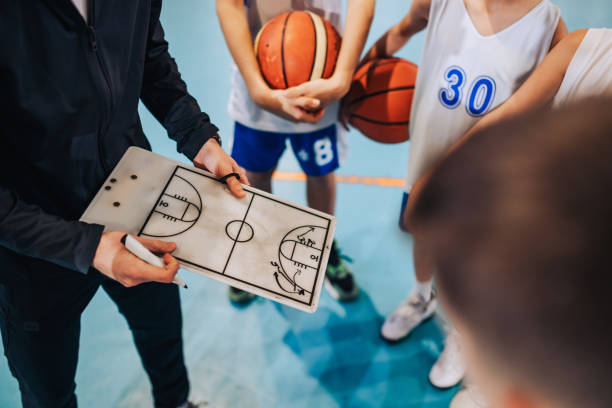istock Cropped image of basketball coach working on game plan with junior team 2154057753