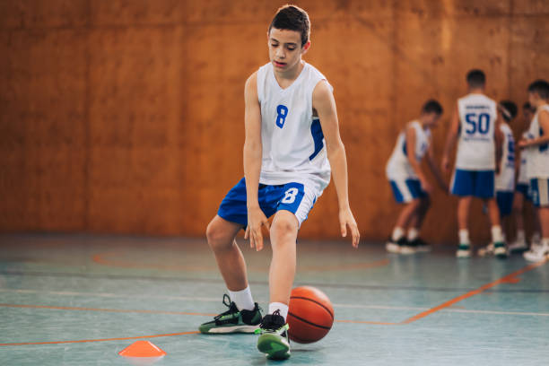 istock A junior basketball player dribbling a ball on court on training. 2154057817