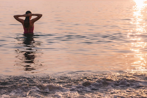 istock Woman relaxing in the water at sunset. 2154058639
