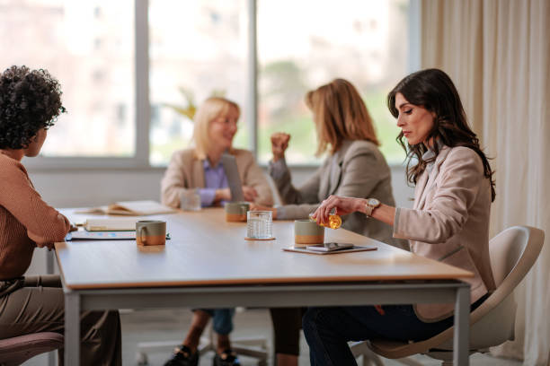 istock Businesswoman pouring herself a drink at work. 2154058712