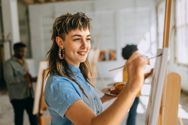 istock Art class in progress: teacher and students painting on canvas 2154059606