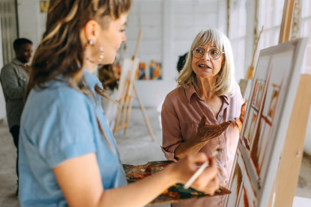 istock Art class in session: teacher guiding student through canvas painting 2154059871