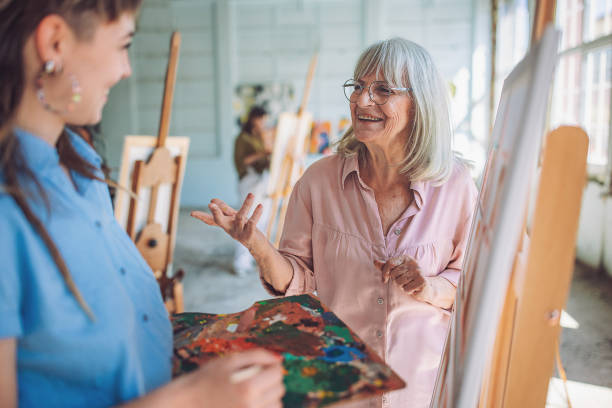 istock Art teacher and students engage in canvas painting workshop 2154060078