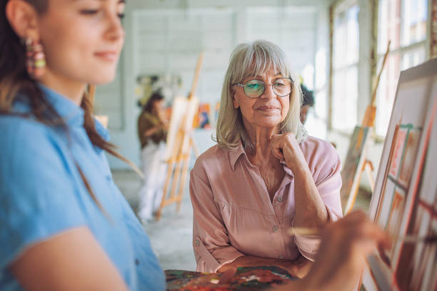 istock Art instructor guiding students in a painting class 2154060190