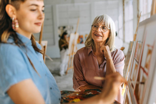 istock Art school creativity: teacher guiding students in painting class 2154060380