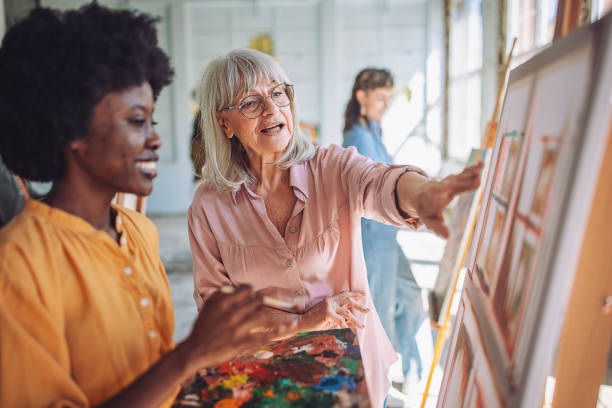 istock Art class in session: teacher guiding students in painting techniques 2154061414