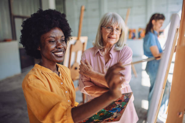 istock Art teacher guiding students in painting workshop 2154061602