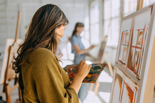 istock Art class in session: teacher and students engaged in painting 2154062027