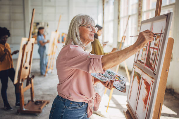 istock Art class engagement: teacher and students painting on canvas 2154064182