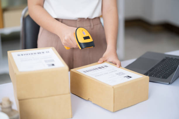 istock Young business online woman scanning package label with barcode reader at storehouse. 2154064433