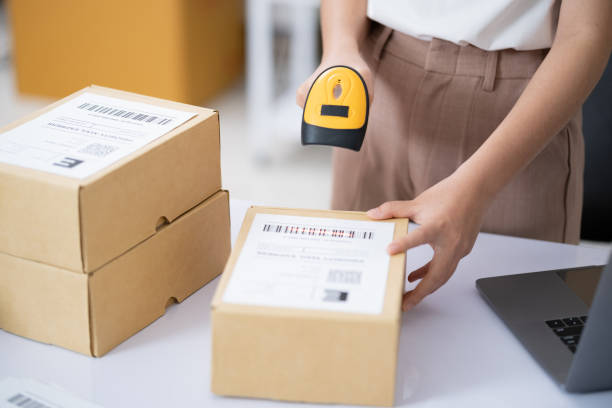 istock Young business online woman scanning package label with barcode reader at storehouse. 2154064435