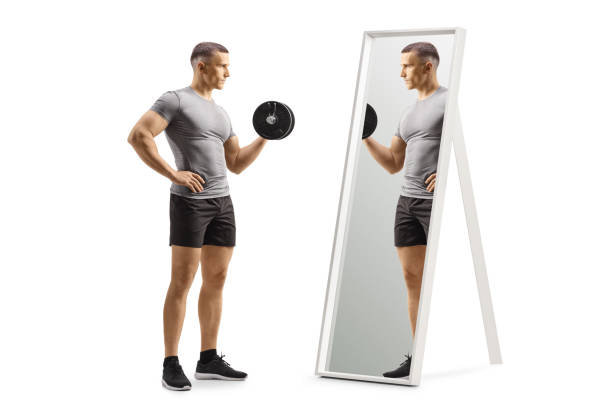 istock Man lifting a dumbbell and looking at a mirror 2154066586