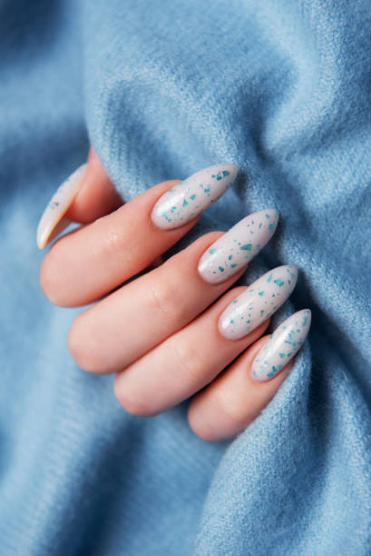 istock Female hands with blue nail design on blue textile background. 2154077572