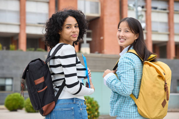 istock Two multiethnic students are smiling and holding backpacks 2154079814