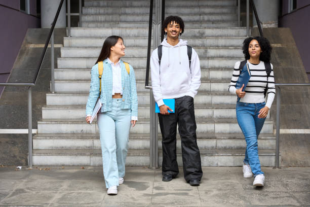 istock Three young students are walking up a set of stairs, each carrying a backpack 2154079858