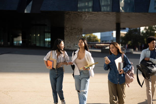 istock Happy College Students Walking Together on Campus 2154084132