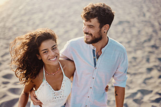 istock Happy couple enjoying in summer walk on the beach. 2154086724